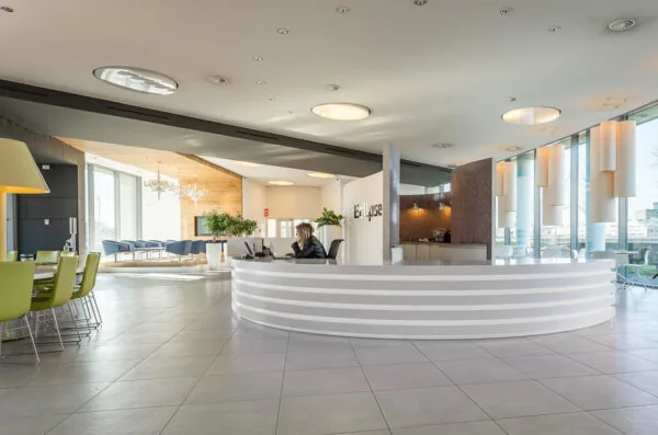 Moderne receptieruimte van het kantoorgebouw Eclipse aan het Rivium Quadrant, met een ronde balie en een zithoek.